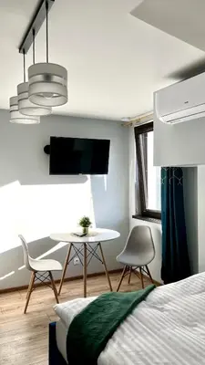 a bedroom with a bed and a table and chairs at Aparthotel w Dolinie Stawów Zator in Zator