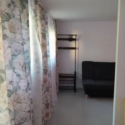 a living room with a couch and a curtain at Domek Krukk blisko Energylandii Zator in Zator