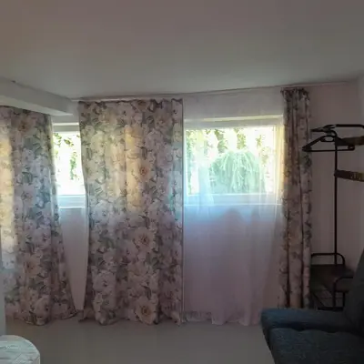 a room with a window with floral curtains at Domek Krukk blisko Energylandii Zator in Zator