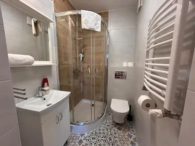 a bathroom with a shower and a toilet and a sink at Old Town Apt Kącik Street K10 in Kraków