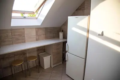 a kitchen with a refrigerator and two stools at Jurajska47 - trójka in Wola Kalinowska