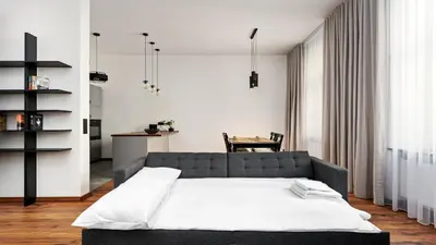 a bedroom with a bed and a table at Old Town Deluxe Apartment by BookingHost in Kraków