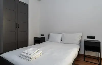 a bedroom with a bed with white sheets and pillows at Old Town Deluxe Apartment by BookingHost in Kraków