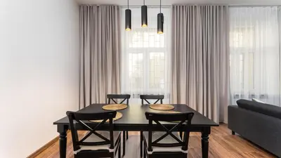 a dining room table with four chairs and a couch at Old Town Deluxe Apartment by BookingHost in Kraków