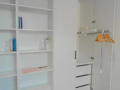 a white closet with white shelves and a door at Długa 17 Residence in Kraków