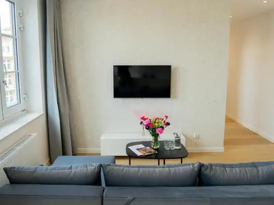 a living room with a couch and a table with flowers at Długa 17 Residence in Kraków