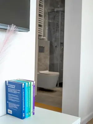 a stack of books sitting on a counter in a bathroom at Długa 17 Residence in Kraków