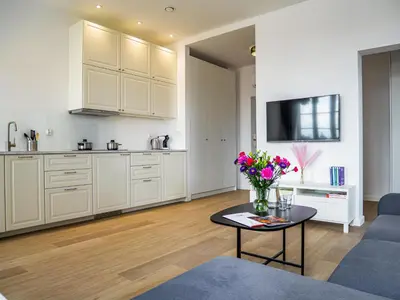 a living room with a vase of flowers on a table at Długa 17 Residence in Kraków
