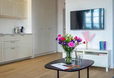 a vase of flowers on a table in a kitchen at Długa 17 Residence in Kraków