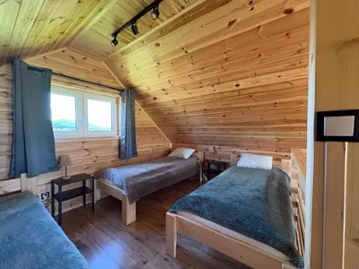 a room with two beds in a log cabin at Beskid Barns - Domek z Balią i Widokiem na Babią Górę in Jordanów