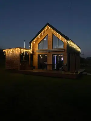 a house lit up at night with lights on it at Beskid Barns - Domek z Balią i Widokiem na Babią Górę in Jordanów