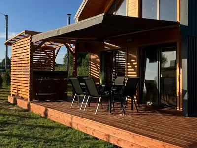 a wooden deck with a table and chairs on it at Beskid Barns - Domek z Balią i Widokiem na Babią Górę in Jordanów