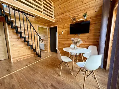 a room with a table and chairs and a tv at Beskid Barns - Domek z Balią i Widokiem na Babią Górę in Jordanów