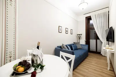 a living room with a white table and a blue couch at Klimatyzowany apartament Dworzec Główny Stare Miasto in Kraków
