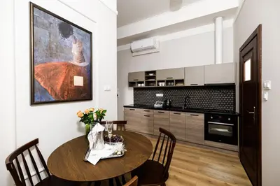 a kitchen with a table and chairs and a painting on the wall at Klimatyzowany apartament Dworzec Główny Stare Miasto in Kraków