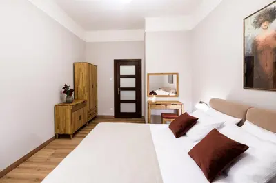 a bedroom with a white bed and a mirror at Klimatyzowany apartament Dworzec Główny Stare Miasto in Kraków