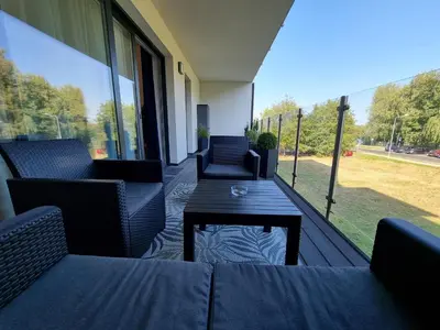 a patio with couches and a table on a balcony at Aurum Apartment in Oświęcim