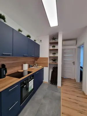 a kitchen with blue cabinets and a skylight at Aurum Apartment in Oświęcim