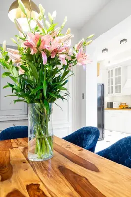 a vase of pink flowers sitting on a wooden table at Househost Apartment Bogusławskiego 76 in Kraków