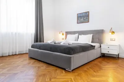 a large bed in a bedroom with a wooden floor at Househost Apartment Bogusławskiego 76 in Kraków