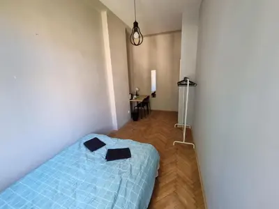 a bedroom with a blue bed and a desk at Fantastic-Inn Kraków - KR63 in Kraków