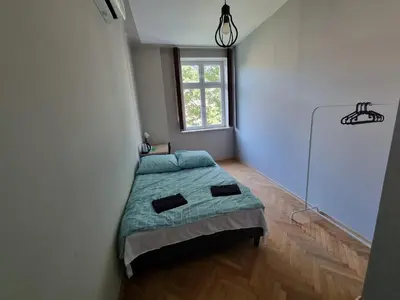 a bedroom with a bed in a room with a window at Fantastic-Inn Kraków - KR63 in Kraków