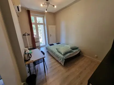 a bedroom with a bed and a table and a window at Fantastic-Inn Kraków - KR63 in Kraków
