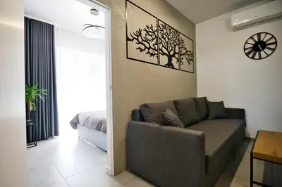 a living room with a couch and a clock on the wall at Revel Apart in Zator
