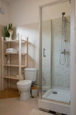 a bathroom with a toilet and a glass shower at Funny Apartment in Kraków
