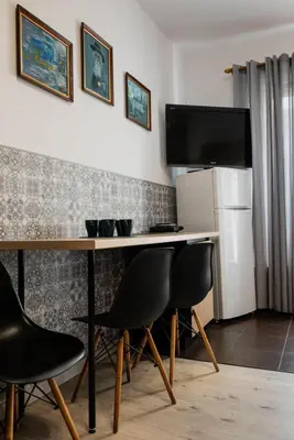 a room with a desk with chairs and a television at Funny Apartment in Kraków