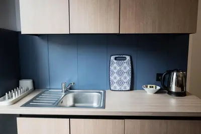 a kitchen counter with a sink and a cell phone at Funny Apartment in Kraków