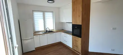 a kitchen with white cabinets and a sink and a window at Solny apartament