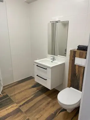 a white bathroom with a toilet and a mirror at Solny apartament
