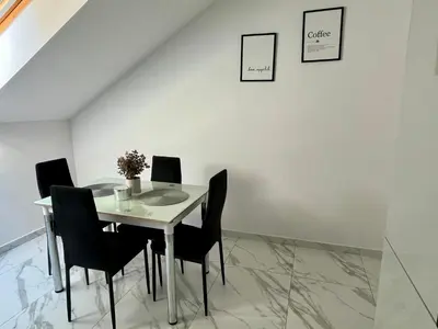 a dining room table with black chairs and a white wall at Kraków Litewska Vintage in Kraków