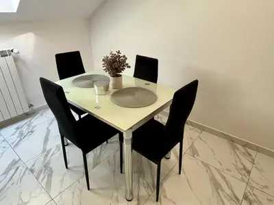 a dining room table with black chairs and a white table at Kraków Litewska Vintage in Kraków