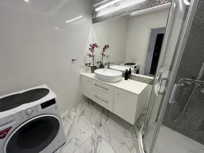 a white bathroom with a sink and a washing machine at Kraków Litewska Vintage in Kraków