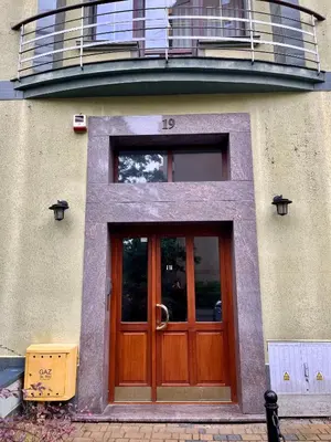 a building with a wooden door and a balcony at Kraków Litewska Vintage in Kraków