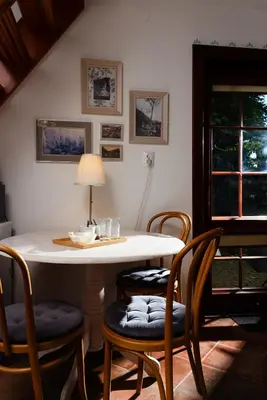 a dining room with a table with chairs and a lamp at Apartamenty Pod Bocianem in Ojców