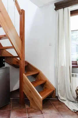 a wooden staircase in a room with a window at Apartamenty Pod Bocianem in Ojców