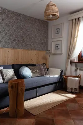 a living room with a blue couch and a rug at Apartamenty Pod Bocianem in Ojców