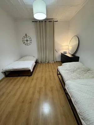 a bedroom with two beds and a mirror on the wall at Urban rooms in Kraków