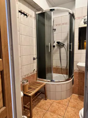 a shower with a bench in a bathroom at Urban rooms in Kraków