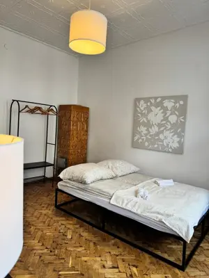 a bed in a room with a lamp at Urban rooms in Kraków