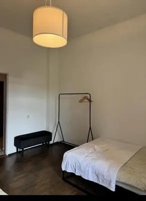 a bedroom with a bed and a lamp and a table at Urban rooms in Kraków