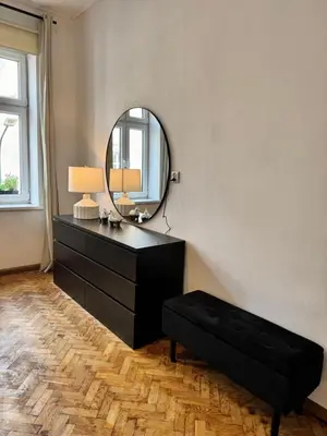 a bathroom with a black dresser and a mirror at Urban rooms in Kraków