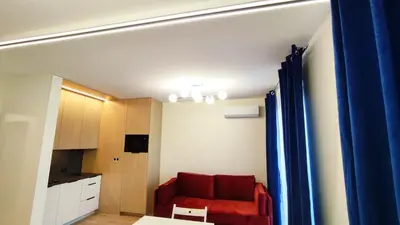 a living room with a red couch and a kitchen at Wieliczka Lux Park in Czarnochowice