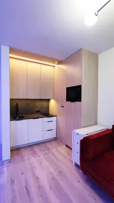 a kitchen with white cabinets and a red couch at Wieliczka Lux Park in Czarnochowice