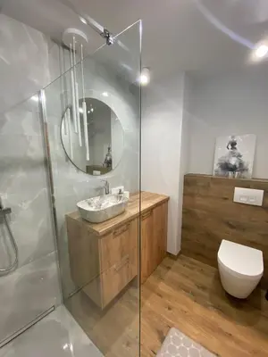 a bathroom with a sink and a toilet and a mirror at Pure Vista Apartment in Kraków