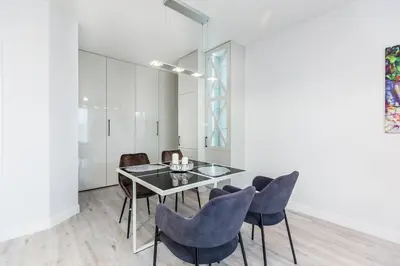 a dining room with a glass table and chairs at Pure Vista Apartment in Kraków