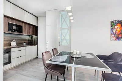 a kitchen and dining room with a table and chairs at Pure Vista Apartment in Kraków
